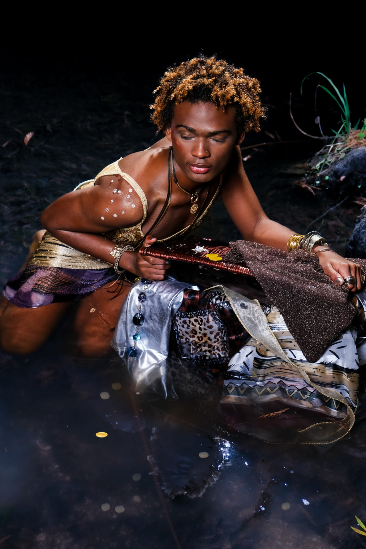 Freeze promo, model kneeling in the water over layered textiles